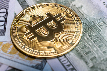 Close up of metal shiny bitcoin crypto currency coin on US dollar bills. Electronic decentralized money concept.