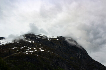 Fototapeta na wymiar Beautiful landscape with mountains and grey clouds in Norway, Geirangerfjord