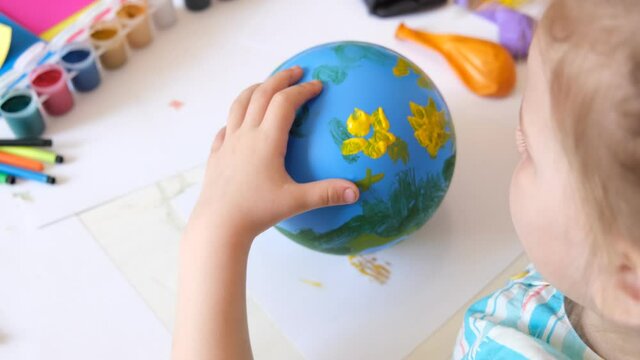 Child drawing pattern of flower and plants on the balloon. Earth day. Arts  crafts concept. art learning and education
