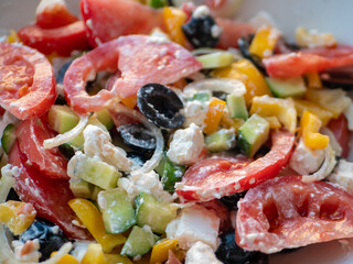 Greek salad. Bright vegetables are cut into wedges. Close-up, selective focus