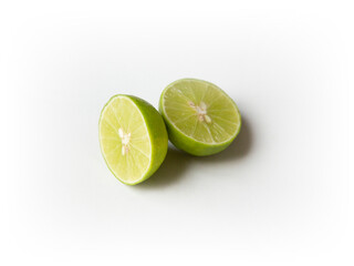 Ripe slice of green lime citrus fruit stand isolated on white background. Lime wedge with clipping path