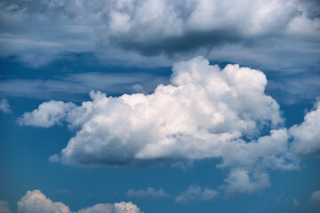 Naklejka na ściany i meble Bright landscape of white puffy cumulus clouds on blue clear sky.