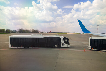 Airplane wing and special bus for moving passengers from aircraft to terminal.