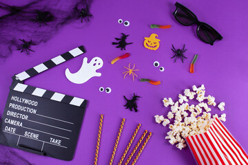 Movie Clapper board in spider webs, spiders, ghost, eyes on purple Lilac Background.