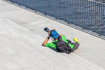Photographer with a camera lies and photographs the subject
