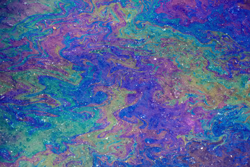 Fototapeta na wymiar Oil stain on water, color gasoline fuel spots as texture or background. environmental pollution concept. Iridescent stains of gasoline, top view