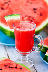 Delicious healthy refreshing low calories summer drink: watermelon smoothie or juice. Concept of seasonal desserts, detox, dieting. White wooden background, close up, macro