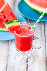 Delicious healthy refreshing low calories summer drink: watermelon smoothie or juice. Concept of seasonal desserts, detox, dieting. White wooden background, close up, macro