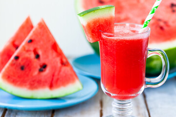 Delicious healthy refreshing low calories summer drink: watermelon smoothie or juice. Concept of seasonal desserts, detox, dieting. White wooden background, close up, macro