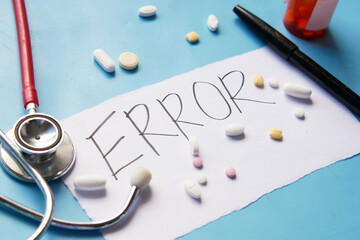 medical error text on a paper with pills and stethoscope on table .
