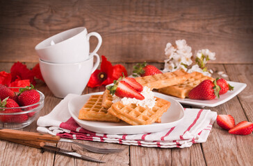 Waffles with strawberries and whipped cream.