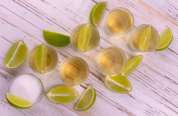 Small glasses with tequila on a white wooden background. Flat lay.
