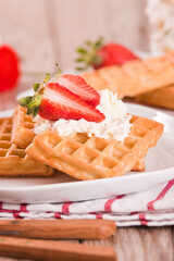 Waffles with strawberries and whipped cream.