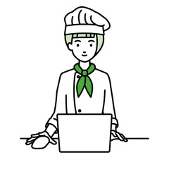 デスクで座ってPCを使っている調理師の女性
