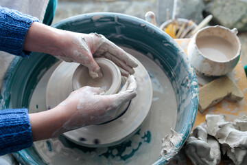 making a clay cup on a potter's wheel. fascinating hobby