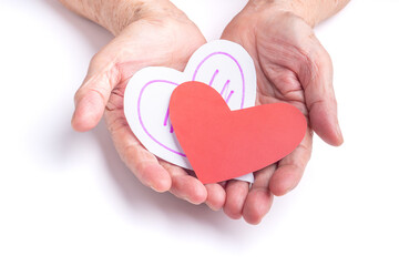 Red and white paper cut a heart shape on the palm of a senior woman with a white background. Healthcare, World heart day, World health day. Valentine's day. People, age, love, and healthcare concep