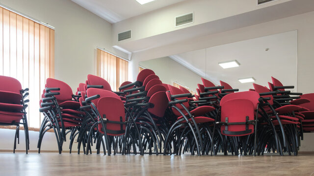 Red chairs stacked in a interior of a large room