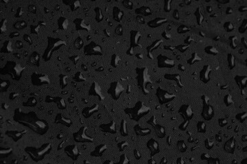 close up of raindrops on black background, macro