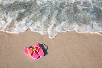 Fototapeta na wymiar Stylish flip flops on beach. Space for text