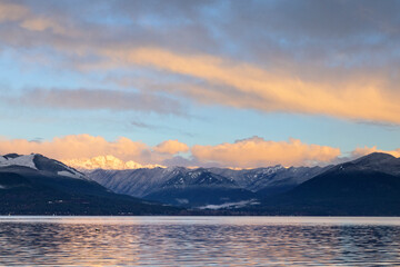 Fototapeta na wymiar Sunrise in the Pacific Northwest over the Olympic Mountains with fresh snow in the hills and early morning light