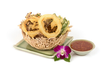 Fried onions and vegetables and dipping sauce on nature background.