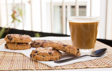 cookies with chocolate and hazelnuts and coffee with milk lie on the table