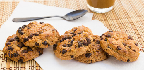 cookies with chocolate and hazelnuts and coffee with milk lie on the table