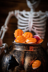 Ein Gerippe zu Halloween, welches einen Kürbis und Süßigkeiten dabei hat und gruselig ist