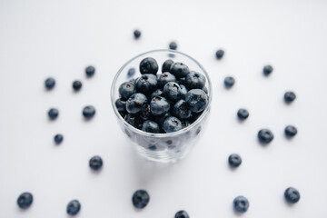 Beautiful ripe blueberries in a transparent glass glass on a white background. Healthy food, and vitamins.