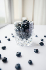 Beautiful ripe blueberries in a transparent glass glass on a white background. Healthy food, and vitamins.