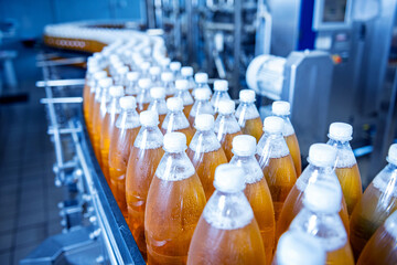 Conveyor belt with bottles for juice or water at a modern beverage plant