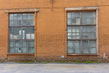 Large old dilapidated red brick house with large dilapidated windows. An old abandoned factory...