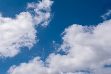 Naklejka na ściany i meble Weiße Wolken vor blauen Himmel an einem sonnigen Tag