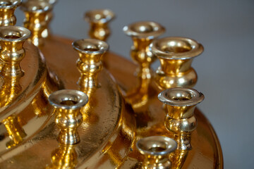 A large brass candlestick without candles standing in an Orthodox church. The interior of the church. A place for prayer and repentance.