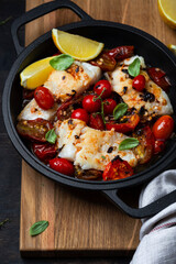 codfish with tomato sauce in a iron pan