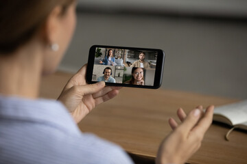 Close up cropped of woman holding phone, involved in group video call, chatting with friends in...