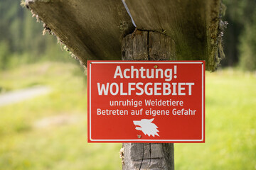 Schild Achtung Wolfsgebiet unruhige Weidetiere Betreten auf eigene Gefahr