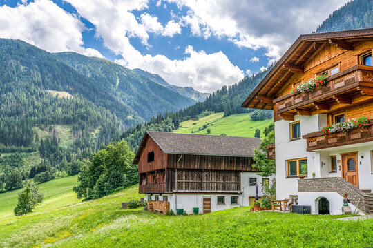 Alpenlandschaft - traditionelle &ouml;sterreichische Bauernh&auml;user  vor einem Berg im Hintergrund , Matrei, S&uuml;dtirol,  &Ouml;sterreich