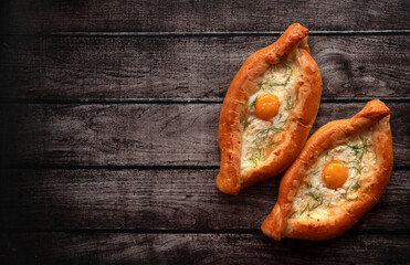 Khachapuri in Adjarian. Open pie with cheese and egg. Georgian cuisine. Top view.