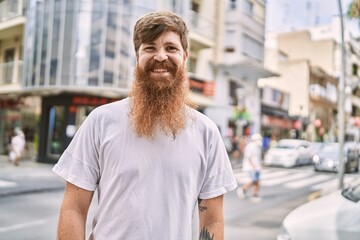 Young redhead man smiling happy standing at the city.