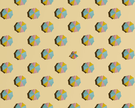 Creative summer pattern against pastel sandy background. Open sun umbrellas and one closed. Minimal individualism concept. 