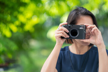 Asian woman holding a camera, professional photographer