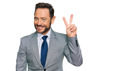 Middle age man wearing business clothes showing and pointing up with fingers number two while smiling confident and happy.