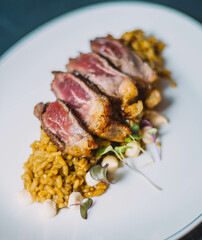 Plato gourmet de  delicados cortes de ternera sobre un exquisito arroz especiado