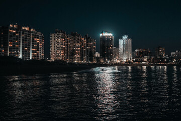 Fototapeta na wymiar Imagen nocturna de unos edificios en una ciudad costera 
