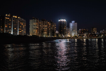 Obraz na płótnie Canvas Imagen nocturna de unos edificios en una ciudad costera 