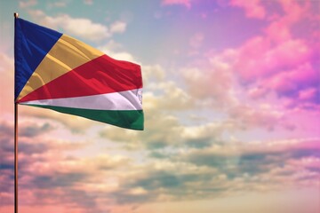 Fluttering Seychelles flag mockup with the space for your content on colorful cloudy sky background. - obrazy, fototapety, plakaty