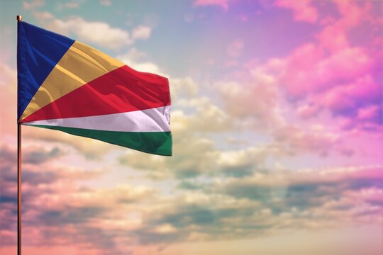 Fluttering Seychelles flag mockup with the space for your content on colorful cloudy sky background.