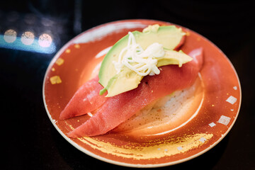 Sushi and Sashimi. Dishes of Sushi and Sashimi rolling on conveyer belt.