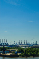 View over the port of Hambrug with cargo ship, cranes and wind turbines | Hamburg, Germany